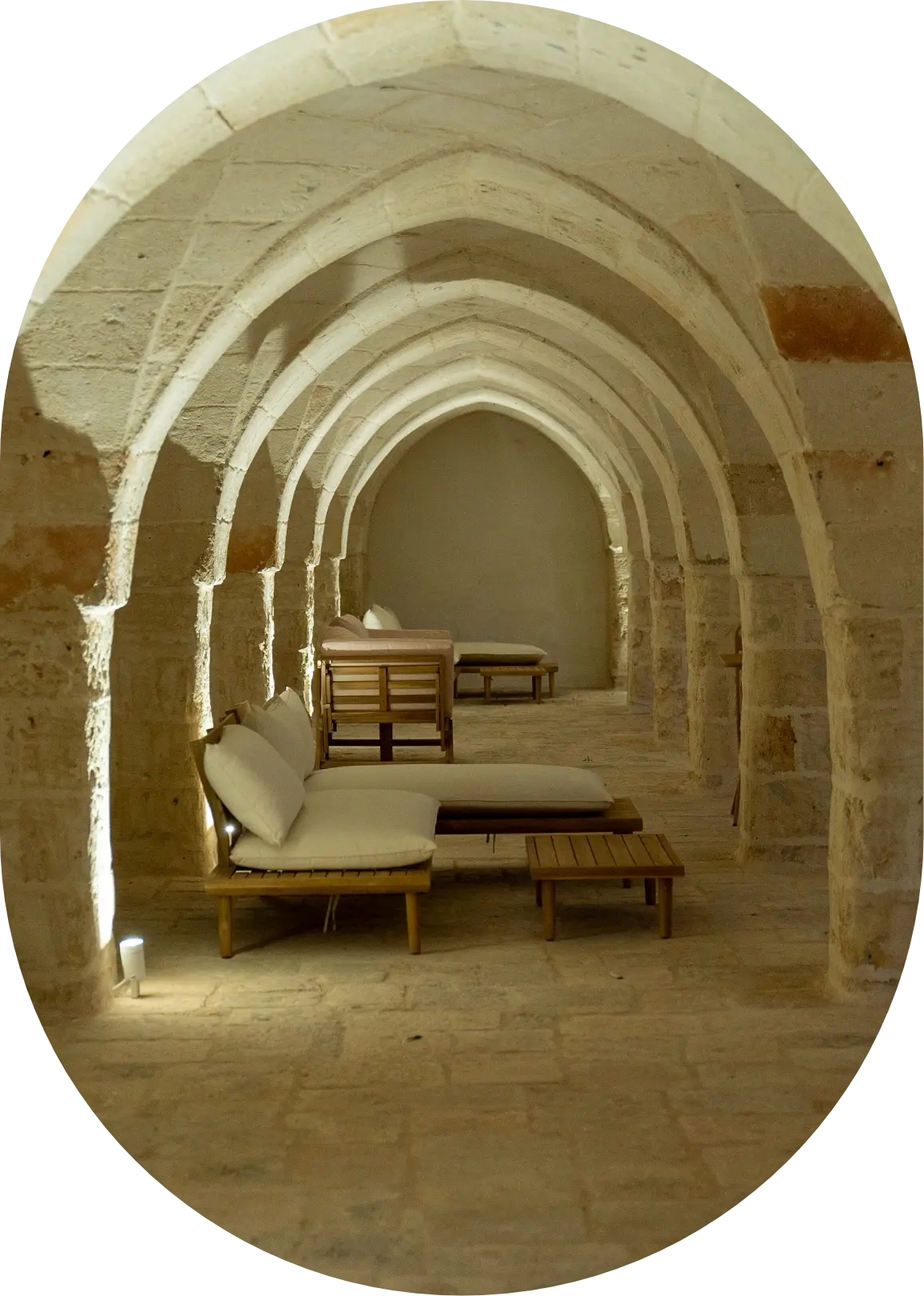 Interno in pietra di masseria salentina con archi a volta e area relax con poltrone in legno chiaro