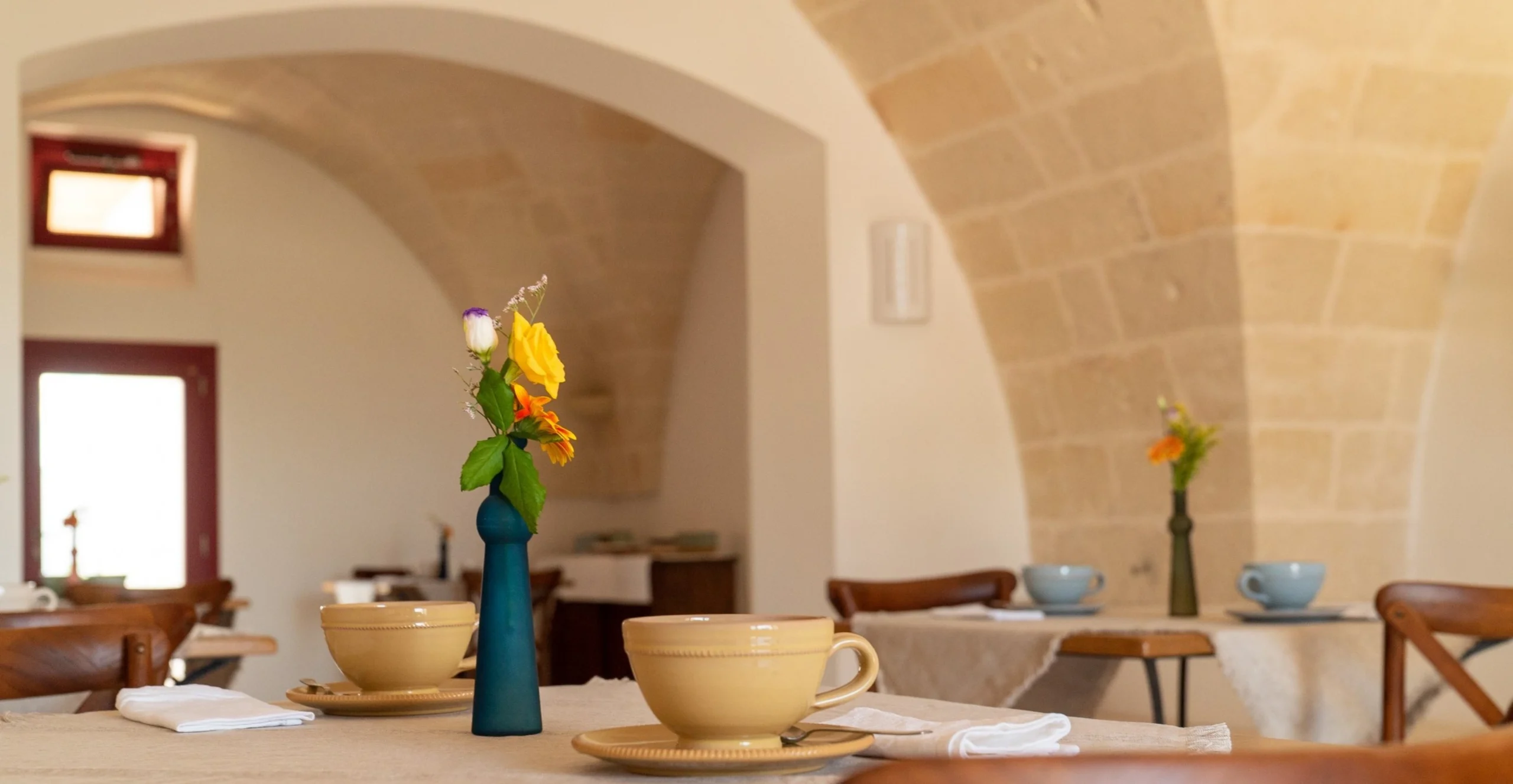 Sala colazioni della Masseria Rescio con volte in pietra e dettagli floreali